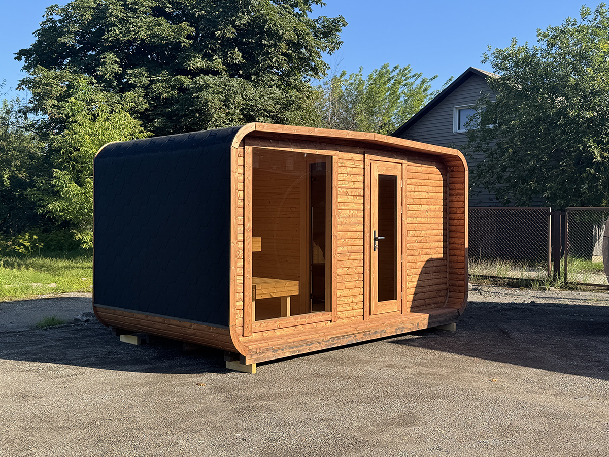 4 m Cube Wide Relax outdoor sauna with teak-coloured timber cladding, a large window and a black roof.